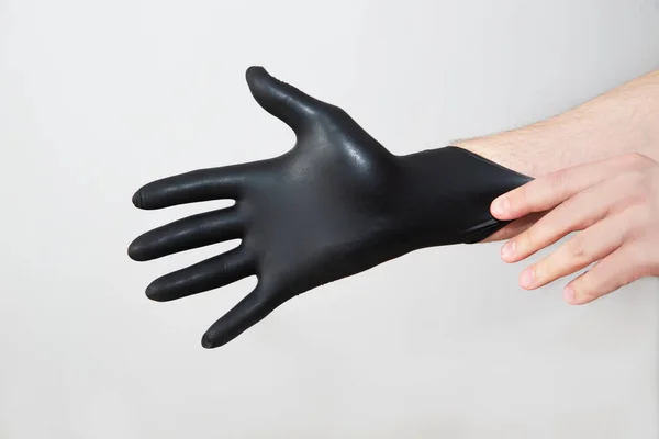 Ktoś Nakłada Ręce Czarne Rękawice Ochronne Chroniące Przed Zarazkami Bakteriami — Zdjęcie stockowe