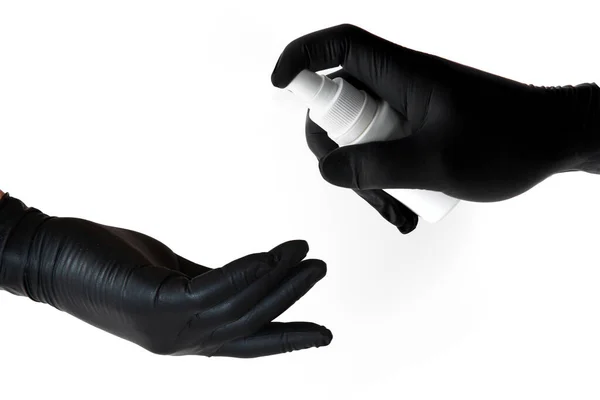一个戴黑色乳胶手套的人的手在另一个没有保护措施的人的手上喷洒消毒剂 以防止在Covid 19流行病期间感染 并保护健康 — 图库照片