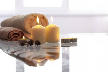 Parlak alevi ve doğal renk ev dekorasyonu havlularıyla güzel yanan sarı krem vanilyalı mumlar.