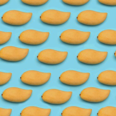 Düz, pürüzsüz, olgun sarı mango meyvesinden yapılmış, mavi arka planda..