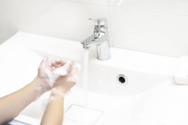 Çocuk ellerini çok fazla sabunla dikkatlice yıkıyor. Hijyen ve grip salgını önleme. Çocuklar için Helth bakımı