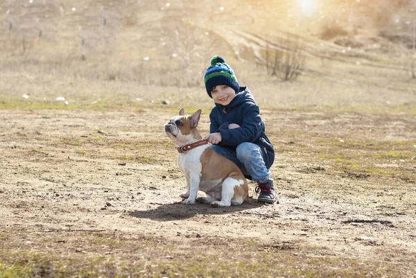 Životní styl portrét chlapce chůze a hraní s frech buldok na slunném jarním dni v přírodním parku Děti — Stock fotografie