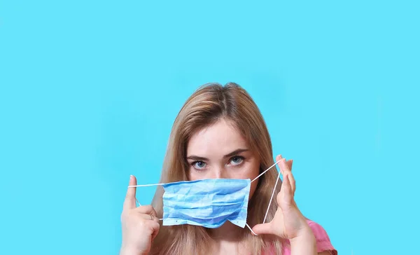 Красивая девушка женщина в изоляции носит маску для лица, которая защищает от распространения коронавируса. Хирургическая маска — стоковое фото