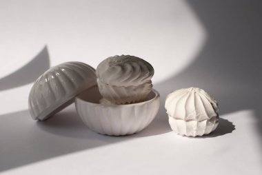 Güzel gölgeli kremalı şekerleme Zephyr. Beyaz ev yapımı zephyr veya lokum. Beyaz arka plan. Hafif kompozisyon. Tatlı tatlı tatlı. Tek Renkli