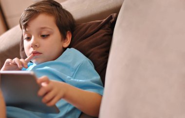 Düşünen küçük çocuk. Çevrimiçi eğitim ve Coronavirus Karantinası. Tablet ve çocuk uzaktan çalışıyor. Salgın çocuklar meşgul ya da evde dinleniyorlar. Ev ödevi hazırlamak için evde kal Boşluğu kopyala
