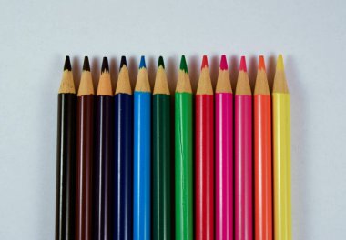 Beyaz arkaplanda farklı renkte tahta kalemler.