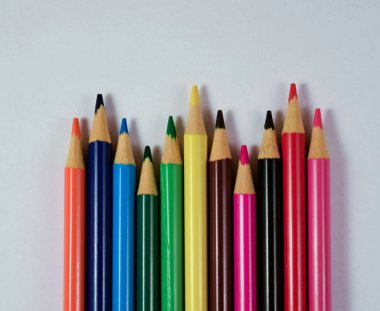 Beyaz arkaplanda farklı renkte tahta kalemler.