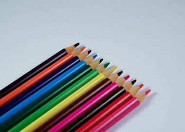 Beyaz arkaplanda farklı renkte tahta kalemler.