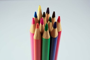 Beyaz arkaplanda farklı renkte tahta kalemler.