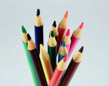 Beyaz arkaplanda farklı renkte tahta kalemler.