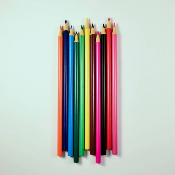 Beyaz arkaplanda farklı renkte tahta kalemler.