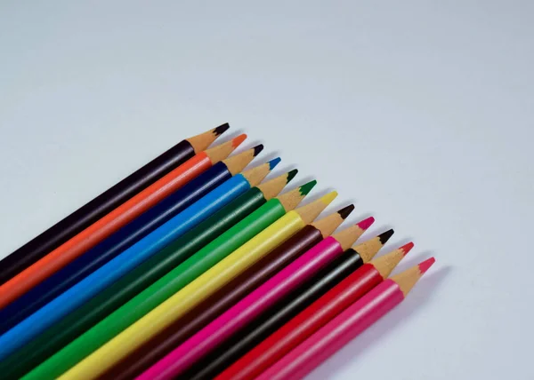 Beyaz arkaplanda farklı renkte tahta kalemler.