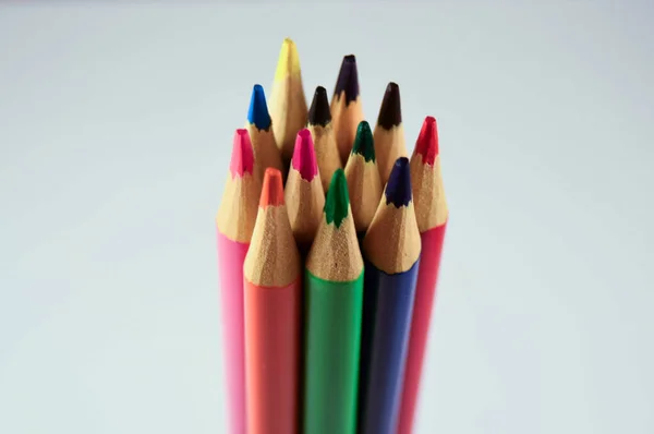 Beyaz arkaplanda farklı renkte tahta kalemler.