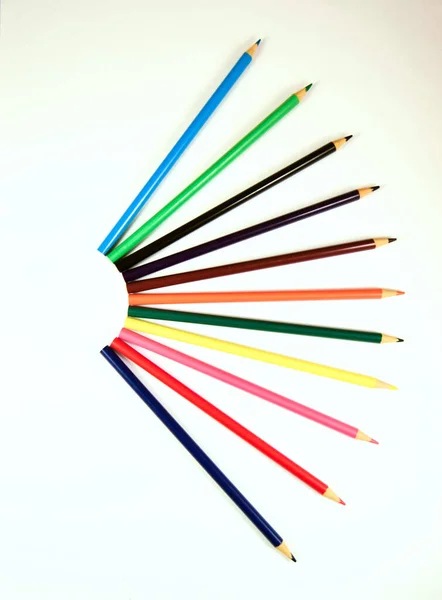 Beyaz arkaplanda farklı renkte tahta kalemler.