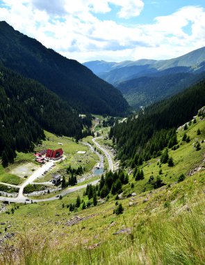 Muhteşem dağ vadisi. Yazın gün doğumunda mükemmel bir asfalt ile güzel bir dağ yolu manzarası. Avrupa dağlarında otoyol. Avrupa, Romanya. Transfagasan yolu.