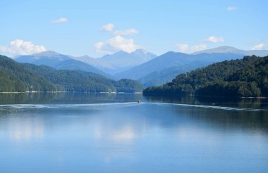 Karpat Dağları 'ndaki Vidraru Gölü' nü (hidroelektrik üretimi) geçen küçük bir zevk teknesi Transfagarasan 'dır (Romanya).)