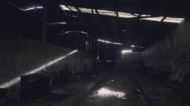 Duvarları ve çatısı aydınlık olan karanlık terk edilmiş çiftlik binası. Ürkütücü, ürkütücü karanlık gölgeler. Örümcek ağları ve toz rastgele nesneleri örter.