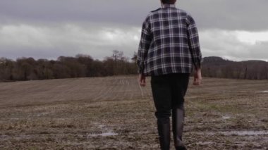 Wellies ve Checkered Jumper 'lı Adam Rüzgarda Sahaya Yürüyor