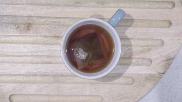 从上往下看蓝色杯子 里面装的是茶和茶袋 里面的水汽向相机涌来 焦点从杯子上升到蒸汽 — 图库视频影像