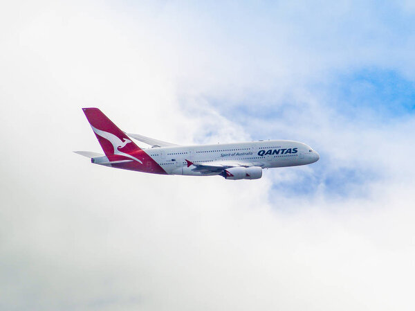 AUSTRALIA, SYDNEY - MARCH 21, 2014: QANTAS A380 flying through a mostly cloudy sky.