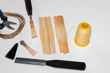 Hüner aletleri ve bambu şeritleri keserek fagot enstrümanı için kamış yapıyorlar.