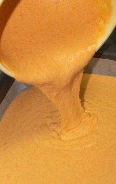 Havuçlu keki pişirmek için tepsiye döküp hamuru karıştır.