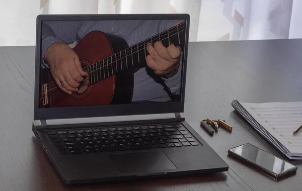 Evde dizüstü bilgisayarla İspanyolca gitar kursunun videosunu izliyordum, covid-19 hapsi sırasında.