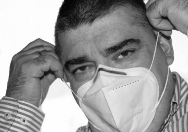 50 yaşında, Coronavirus 'a karşı beyaz koruyucu maske takıyor.