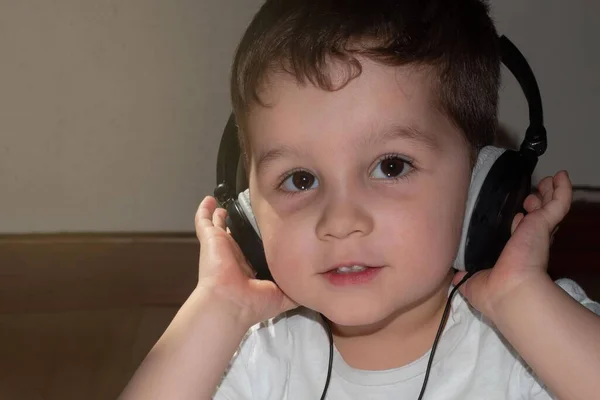 幼い子供はヘッドフォンで音楽を聴くのを楽しみ — ストック写真