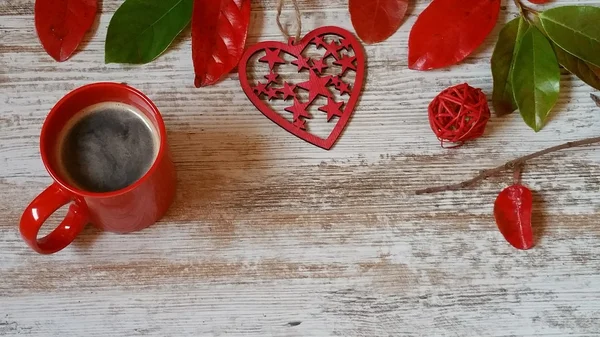 Fincan kahve, kırmızı kalp ve ahşap arka plan üzerinde sonbahar yaprakları 