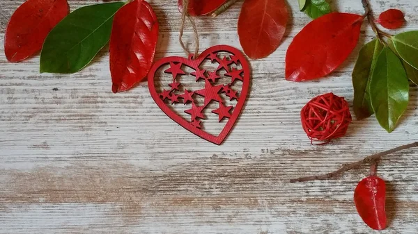 Kırmızı kalp ve ahşap arka plan üzerinde sonbahar yaprakları 