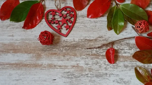 Red heart and autumn leaves on wooden background — Stock Photo, Image
