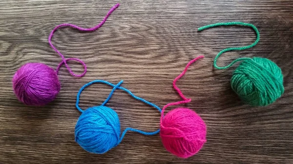 Koyu ahşap arka plan üzerinde renkli iplik 