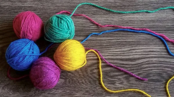 Koyu ahşap arka plan üzerinde renkli iplik 