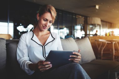 Kadın yatırımcı modern Cafe iş tatilinde dokunmatik yüzey üzerinden İnternet finans haberleri okuyor