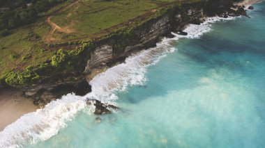 Dalgadalgaları ile Hint Okyanusu yakınlarındaki kayalık kayalık ile yeşil bir adanın uçan drone hava fotoğrafı sörf eğitimi için ideal bir yer.