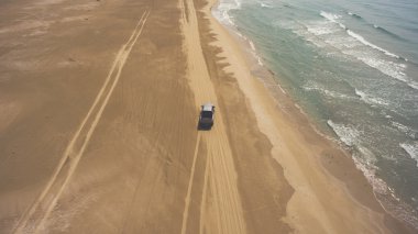 Kazakistan'a yaz gezisi sırasında deniz kıyısında sırasında binicilik pikap araba uçan drone hava fotoğrafı. 