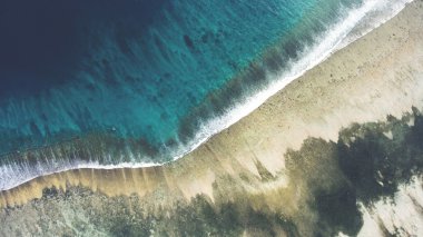 Mercan alt ile bir güzel deniz manzarası ve kopyalama alanı alanı metni ile kumlu plaj drone uçan hava fotoğrafın Üstten Görünüm