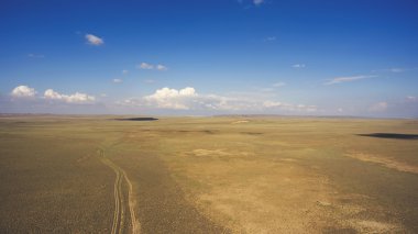 Top view aerial photo from drone of off road way with tires of car in arid dessert valley landscape. clipart