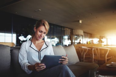 Kadın yatırımcı modern Cafe iş tatilinde dokunmatik yüzey üzerinden İnternet finans haberleri okuyor