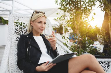 Şık hippi kız hakkında bir şey moda Haberler Internet üzerinden dijital tablet, restoranda dinlenirken okuduktan sonra düşünüyor.