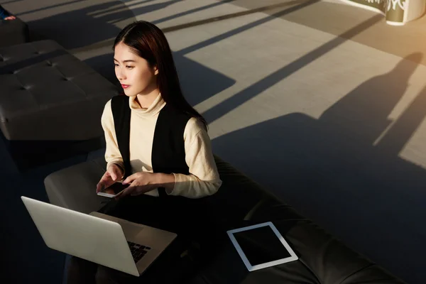 Čínská žena modelu sedí v coworking s miniaplikací — Stock fotografie