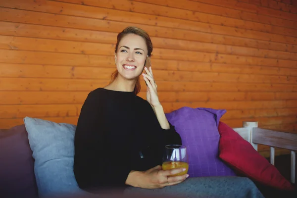 CEO donna sorridente avendo piacevole conversazione smart phone, mentre è in attesa partner commerciali nella moderna caffetteria — Foto Stock
