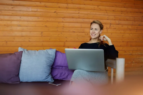 Glückliche Frau freut sich nach positiver Rezension auf net-book über ihr neues Projekt, während sie im Co-Working Space sitzt — Stockfoto