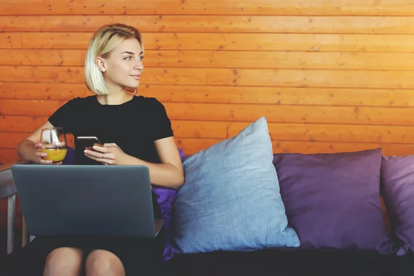 Top view of a young hipster girl is looking at the camera, while is sitting with portable net-book with empty screen in co-working space — Stock Photo, Image