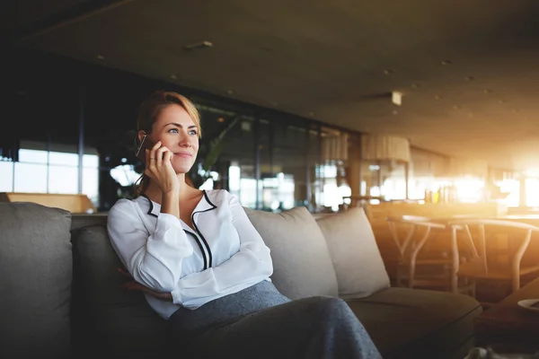 Mujer bonita trabajadora de negocios calificada está llamando a su jefe a través del teléfono inteligente, mientras que está esperando en los socios internacionales de restaurantes . — Foto de Stock