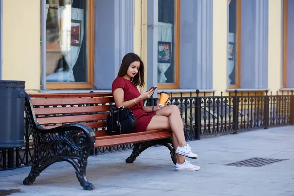 Hermosa mujer está viendo fotos en el teléfono celular lo que hizo durante el paseo — Foto de Stock