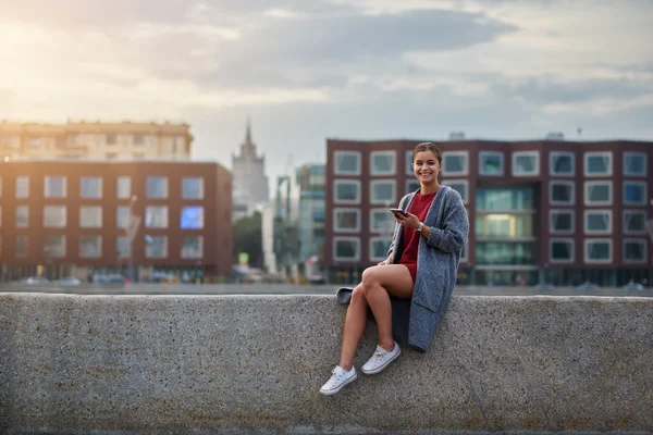 Turistické krásná žena s mobilním telefonem v ruce je těší úžasné jarní den během její víkend v zahraničí. — Stock fotografie