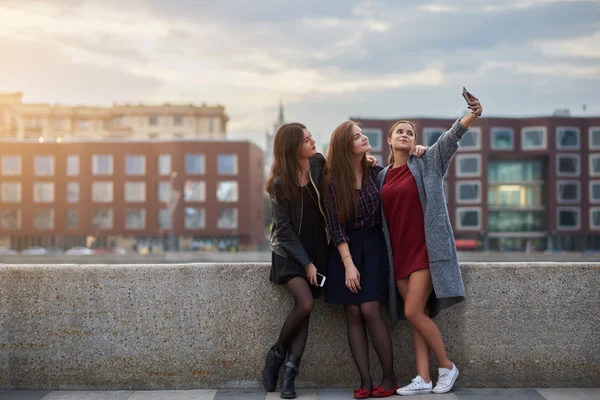 三个美丽的女人最好的朋友正在摆姿势，而正在用手机拍摄视频，而站在河边码头附近 — 图库照片