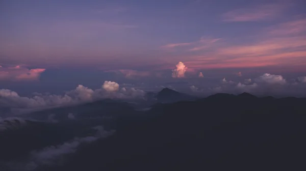 Foto aérea de la cabina de un avión de un cielo increíblemente hermoso y colorido con puesta de sol rosa sobre la silueta de las montañas . — Foto de Stock